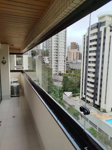 Sacada longa com vidro e vista para prédios